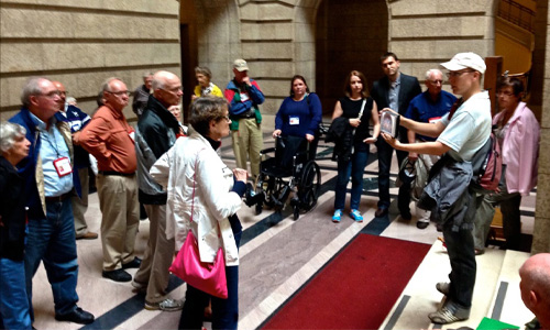 Kristen of SquarePeg Tours explains the history of the Manitoba Legislature to a group of seniors